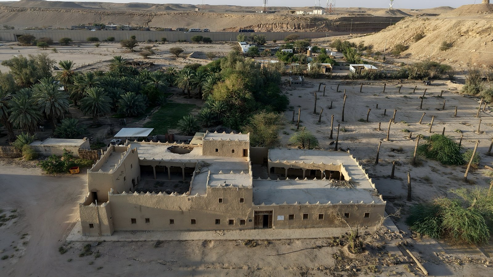 لقطة جوية لقصر طيني تراثي بين النخيل